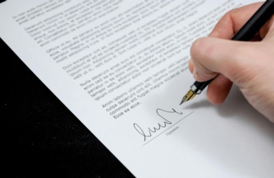 Photo of signing a paper legal document for article on how to scan, back up, and secure (CC0)